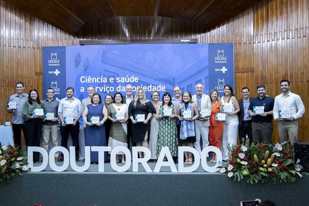 foto de todos os formandos no palco com suas placas em mãos